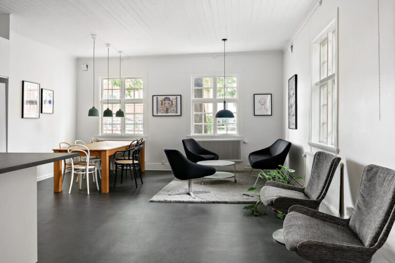 Modern kontorslokal med svart golv och vita väggar.