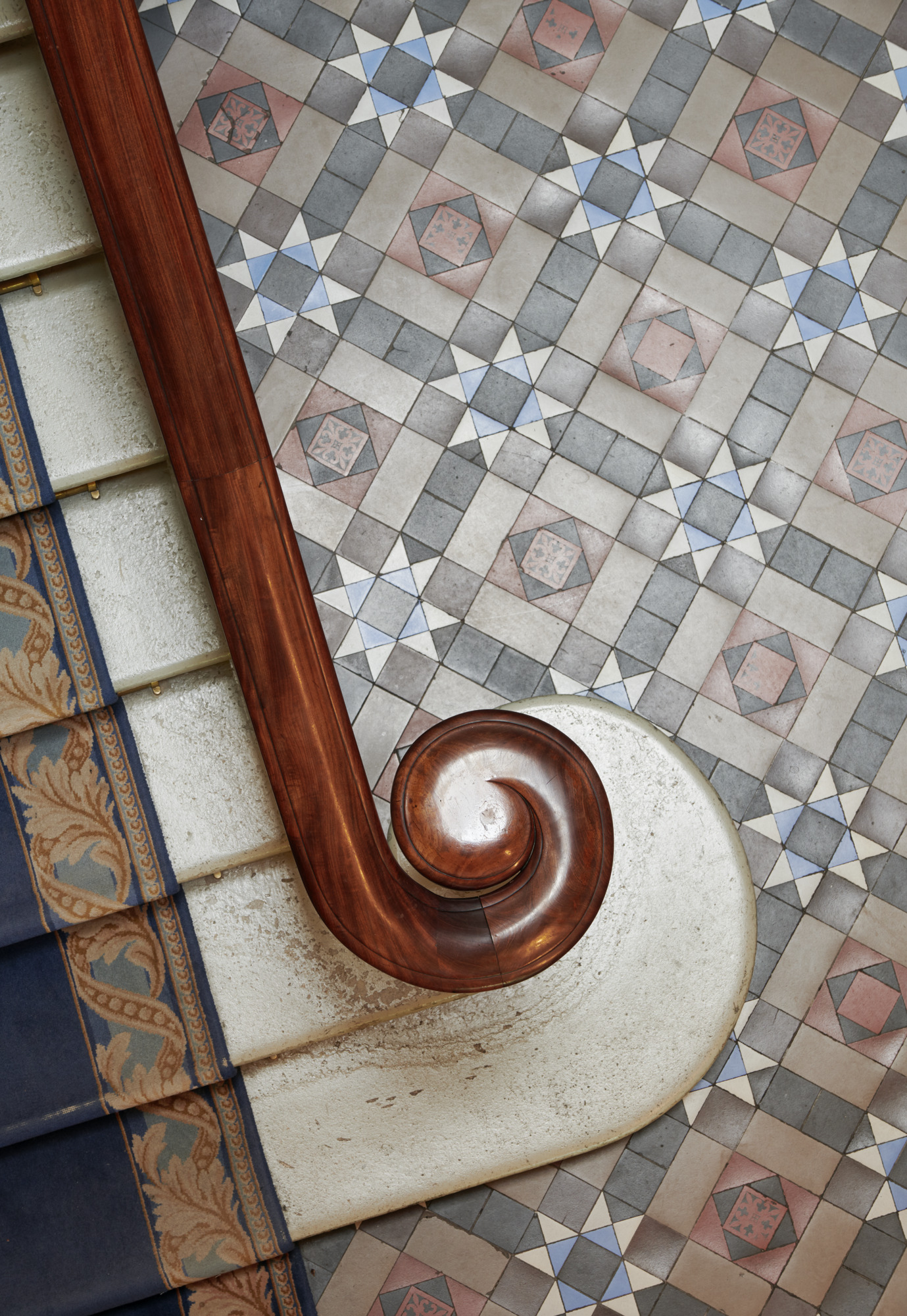 Trappräcke i trä, i bakgrunden klinkergolv med mönster