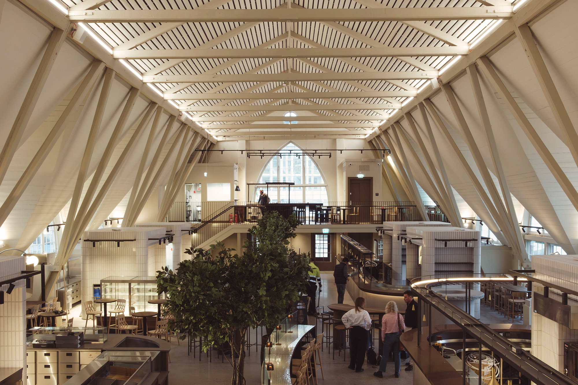 Stor hall med takbjälkar, bardiskar, bord och stolar