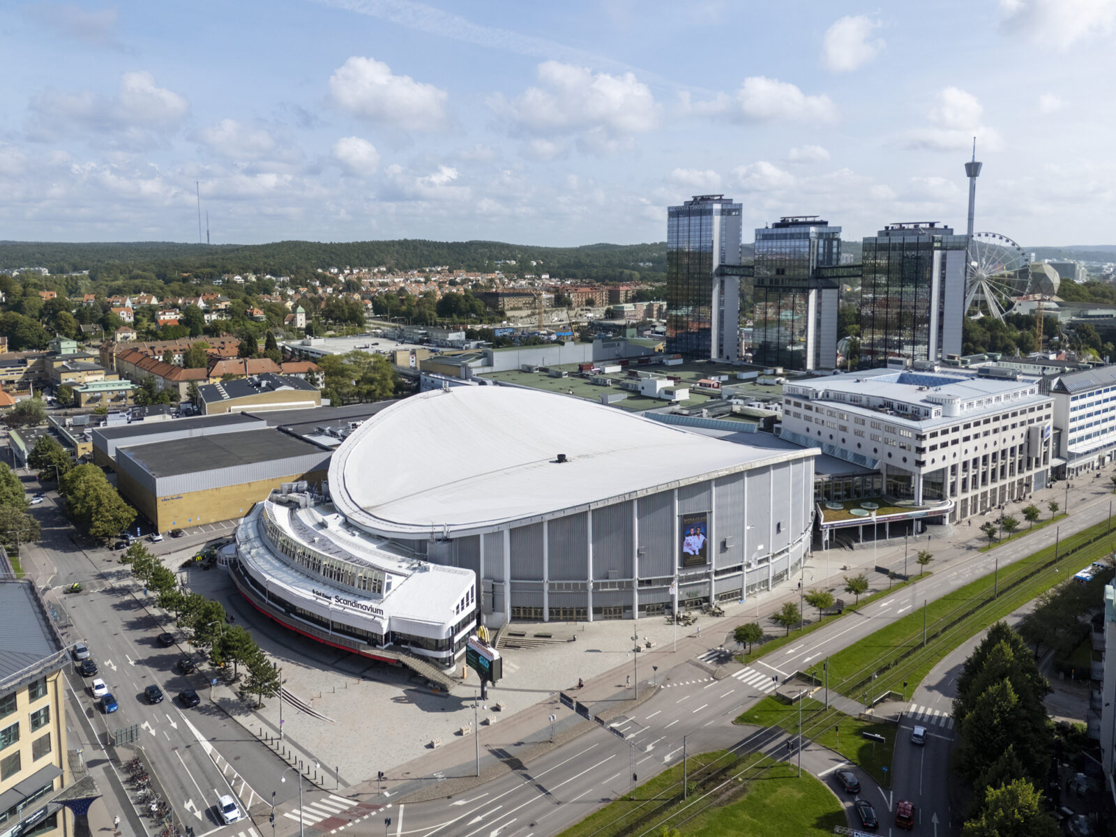 Bild ovanifrån på stadsmiljö med stor arena med höga hus bakom