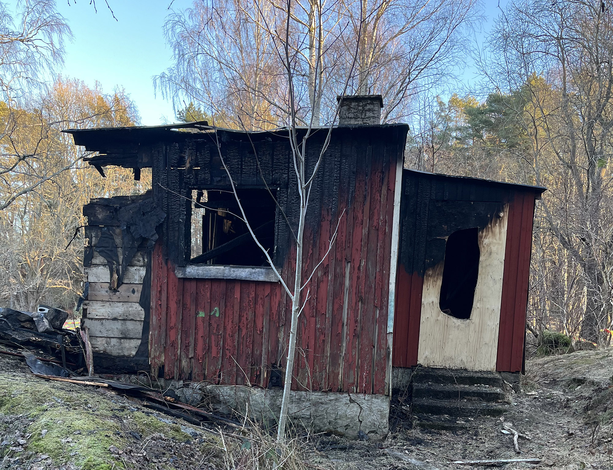 En liten trästuga med brandskador